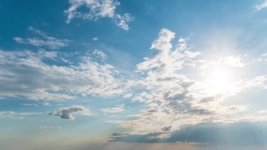 White fluffy clouds slowly float through the blue daytime sky timelapse. Beautiful skies are moving. Airy snow-white clouds move to the side.