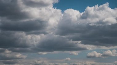 Beyaz kabarık bulutlar mavi gündüz vakti gökyüzünde yavaşça süzülür. Güzel gökyüzü hareket ediyor. Kar beyazı bulutlar yana doğru hareket ediyor..