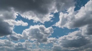 White fluffy clouds slowly float through the blue daytime sky timelapse. Beautiful skies are moving. Airy snow-white clouds move to the side.