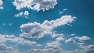 Beyaz kabarık bulutlar mavi gündüz vakti gökyüzünde yavaşça süzülür. Güzel gökyüzü hareket ediyor. Kar beyazı bulutlar yana doğru hareket ediyor..