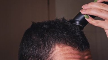Adam saç kesimi ve kırpıcı tarafı ağır çekimde. Berber erkek müşteriye kısa saç kesimi yapıyor. Profesyonel kuaför, gençlerin saçını makasla keser. Elektrikli traşlı erkek kuaförü.