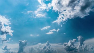 Beyaz kabarık bulutlar mavi gündüz vakti gökyüzünde yavaşça süzülür. Güzel gökyüzü hareket ediyor. Kar beyazı bulutlar yana doğru hareket ediyor..