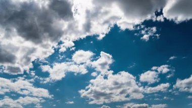 Beyaz kabarık bulutlar mavi gündüz vakti gökyüzünde yavaşça süzülür. Güzel gökyüzü hareket ediyor. Kar beyazı bulutlar yana doğru hareket ediyor..