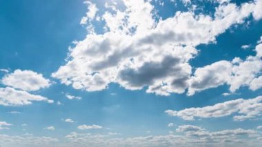 Beyaz kabarık bulutlar mavi gündüz vakti gökyüzünde yavaşça süzülür. Güzel gökyüzü hareket ediyor. Kar beyazı bulutlar yana doğru hareket ediyor..