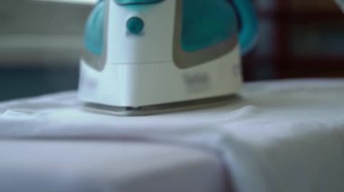 Demir ağır çekimde buhar yayar. Genç bir kadın ütü masasında giysileri ütülüyor. Bir ev hanımı rutin ev işlerini yapar. İşlerle ilgilenmek ve onları düzene sokmak..