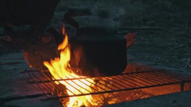 Tencere dibin kara seninki benden kara, seninki benden kara. Ormanda piknik. Çaydanlık yanıyor ve su kaynatıyor. Bir çaydanlık odun ateşinde ısıtılır..