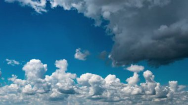 Beyaz kabarık bulutlar mavi gündüz vakti gökyüzünde yavaşça süzülür. Güzel gökyüzü hareket ediyor. Kar beyazı bulutlar yana doğru hareket ediyor..