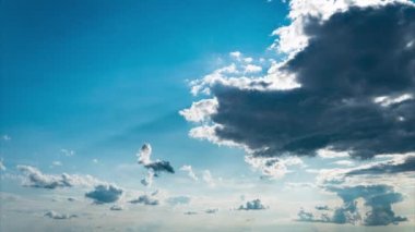 White fluffy clouds slowly float through the blue daytime sky timelapse. Beautiful skies are moving. Airy snow-white clouds move to the side.