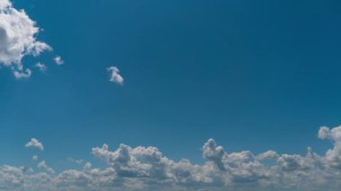 Beyaz kabarık bulutlar mavi gündüz vakti gökyüzünde yavaşça süzülür. Güzel gökyüzü hareket ediyor. Kar beyazı bulutlar yana doğru hareket ediyor..
