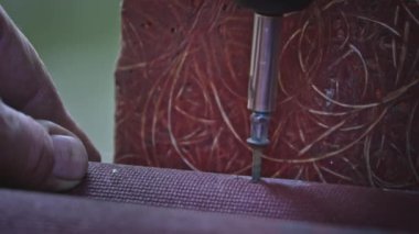 Ağır çekimde tornavidayla sıkışan bir çivinin yakın çekimi. Erkek eli vidaya sokulur. Erkek ev işi. Bir işçi vidayı sıkar. Marangozluk ve inşaat işleri yakın plan..