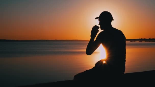 Silhouette Eines Mannes Bei Sonnenuntergang Der Allein Kaffee Trinkt Ein — Stockvideo