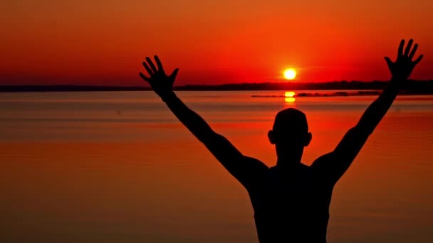 Silhouetten Eines Mannes Mit Erhobenen Händen Allein Bei Sonnenuntergang Ein — Stockvideo