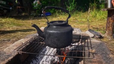 Tencere dibin kara seninki benden kara, seninki benden kara. Ormanda piknik. Çaydanlık yanıyor ve su kaynatıyor. Bir çaydanlık odun ateşinde ısıtılır..
