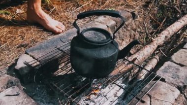 Tencere dibin kara seninki benden kara, seninki benden kara. Ormanda piknik. Çaydanlık yanıyor ve su kaynatıyor. Bir çaydanlık odun ateşinde ısıtılır..