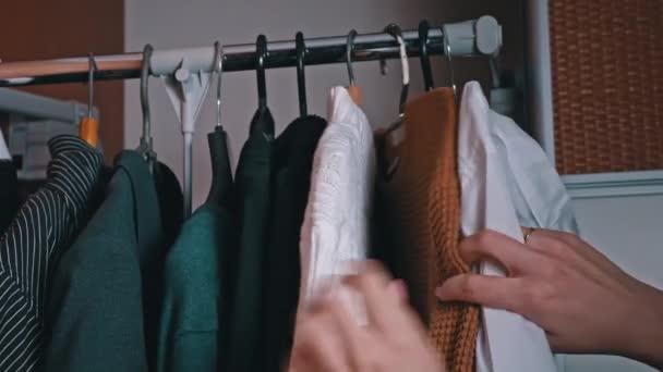 Vrouwen Hand Selecteert Dingen Een Hanger Close Een Meisje Geeft — Stockvideo