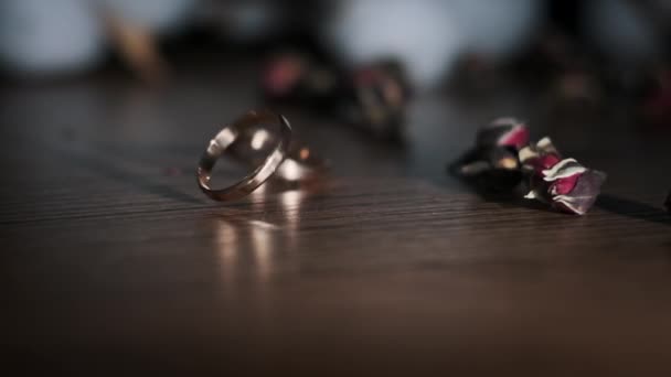 金戒指缓缓地落在桌上 结婚配件的手指 两个相爱的心永远在一起 婚礼日 交换戒指 — 图库视频影像