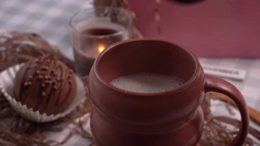 Kakao bombası bir bardak sıcak sütte erir. Bir fincan koyu sıcak çikolata. Çikolata topu bombasıyla sıcak çikolata yapıyorum..