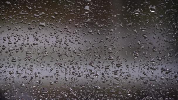 雨点在汽车行驶的背景下顺着玻璃流下 水流从窗户流到雾蒙蒙的玻璃杯上 城市雨 气象学 — 图库视频影像