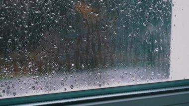 Bardaktan akan yağmur damlaları hareket halindeki arabaların arka planına çarpıyor. Yağmurlu bir hava. Su akıntıları pencereden sisli cama akıyor. Şehir yağmuru. Meteoroloji.