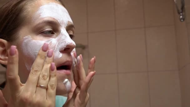 女孩在她的脸上做美容治疗 年轻女孩的画像 她照顾自己的脸 用棉垫擦拭她的脸 用补丁包扎她的眼睛周围的皮肤 戴上面具 — 图库视频影像