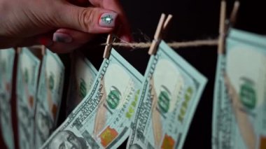Dolar, kripto para birimi grafiğinin arka planında bir mandalda asılı duruyor. Borsa ve borsa fiyat verileri borsa duvarında. Mali endeksler zamanla yükselip alçalıyor.