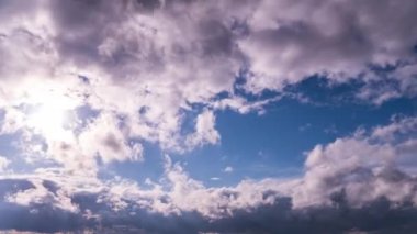 White fluffy clouds slowly float through the blue daytime sky timelapse. Beautiful skies are moving. Airy snow-white clouds move to the side.