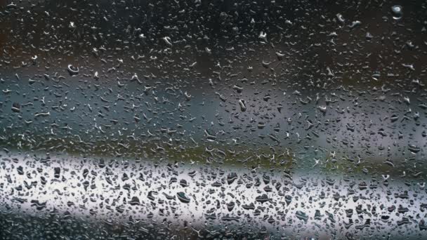 雨点在汽车行驶的背景下顺着玻璃流下 水流从窗户流到雾蒙蒙的玻璃杯上 城市雨 气象学 — 图库视频影像