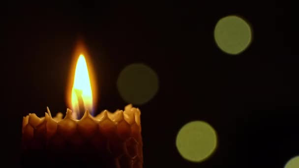 蜡蜡烛在黑色的背景上燃烧 蜡烛点亮黄灯 巨大的蜡烛焰烧黄了 房子里没有光 温暖来自蜡烛 沉默一分钟 — 图库视频影像
