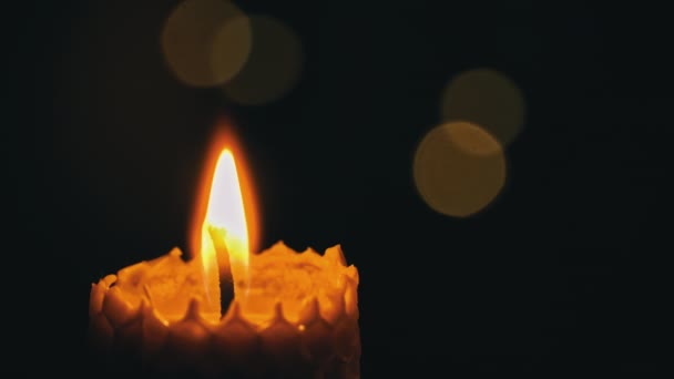蜡蜡烛在黑色的背景上燃烧 蜡烛点亮黄灯 巨大的蜡烛焰烧黄了 房子里没有光 温暖来自蜡烛 沉默一分钟 — 图库视频影像