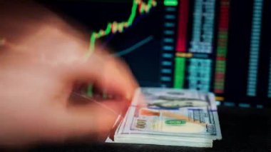 Kripto para biriminin arka planında büyüyen dolar yığını. Kağıt para, nakit para ve bitcoin. 100 dolarlık banknotlar. Kripto dünyasında yatırım başarısı.