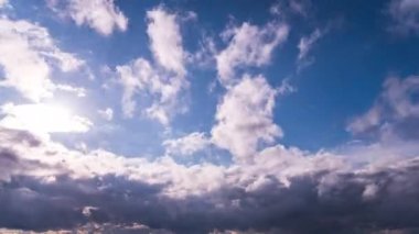 White fluffy clouds slowly float through the blue daytime sky timelapse. Beautiful skies are moving. Airy snow-white clouds move to the side.
