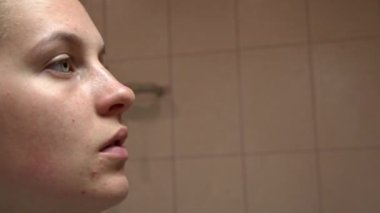 Kız yüzüne yakın plan güzellik tedavisi uyguluyor. Yüzüne özen gösteren, yüzünü pamukla temizleyen, gözlerinin etrafına yamalar yapıştıran, maske takan genç bir kızın portresi.