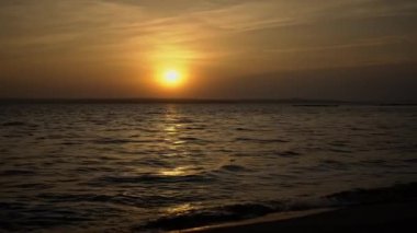 Deniz üzerinde gün batımı ufku. Suyun yanında. Gökyüzünde güzel bir akşam gün batımı manzarası. Güneşin yolu deniz yüzeyine yansır. Doğa. Nehir üzerinde güzel bulutlar.