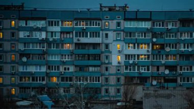 Çok katlı bir binanın penceresinde gece sürati atlaması. Büyük bir şehirde hayat. Işık Serenadı. Geceleri yanıp sönen apartman pencerelerinin hızlandırılmış görüntüleri..