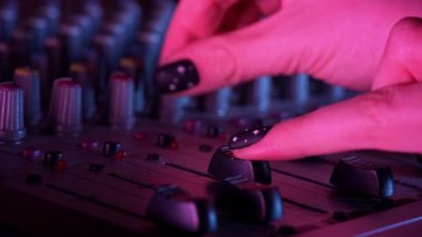 DJ mikserle çalışan bir DJ 'in elleri. Profesyonel ses karıştırıcı, manuel ayarlar, düğmeler ve dengeleyiciler, ev stüdyosu için müzik masası. DJ