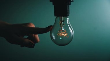 Ampul, karanlıkta bir insan elinin dokunuşuyla açılıp söner. Tungsten ampulü yavaş yavaş açıp kapanıyor. Yanıp sönen eski bir ampulün filamanı. Enerji, elektrik, ışık