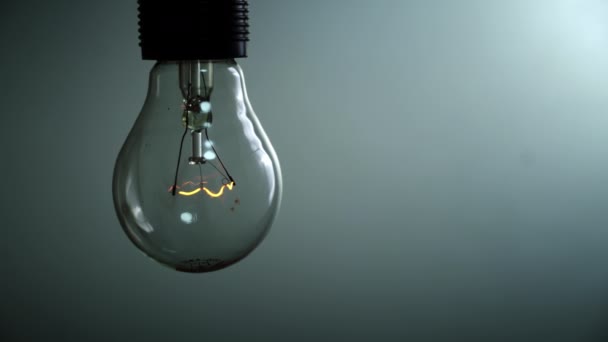 Light Bulb Lights Goes Out Blue Background Dark Slow Turning — Video Stock
