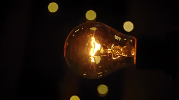 老式灯泡在摇曳的灯光背景下发光 蜡烛白炽灯闪烁着金光 产生的想法 创新和创造力 灯里面有闪亮的大脑 — 图库视频影像