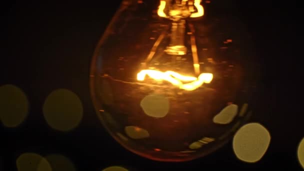 ヴィンテージの電球は点滅するライトの背景に対して光ります ペンダントの白熱ランプは黄金色の光で輝きます アイデアの生成 イノベーションと創造性 中光沢のある脳を持つランプ — ストック動画