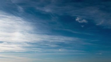 Beyaz kabarık bulutlar mavi gündüz vakti gökyüzünde yavaşça süzülür. Güzel gökyüzü hareket ediyor. Kar beyazı bulutlar yana doğru hareket ediyor..