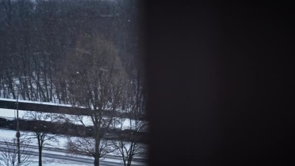 街の雰囲気の中で雪が降っている 冬の街の窓からの眺め 凍った天気 その雪の日と外の温度はゼロを下回っています — ストック動画