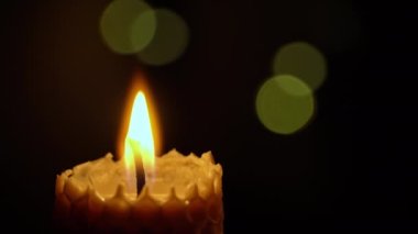 Siyah arka planda mum yanıkları. Mum sarı ışıkları yakar. Büyük mum ateşi sarıyı yakar. Evde ışık yok, sıcaklık bir mumdan geliyor. Yoksulluk, savaş, bir dakikalık sessizlik..