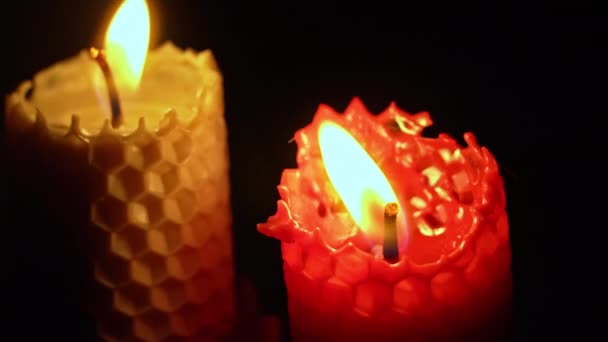 两支蜡蜡烛在黑色的背景上燃烧 蜡烛点亮淡黄色的灯 巨大的蜡火燃烧黄色 房子里没有光 温暖来自蜡烛 沉默一分钟 — 图库视频影像