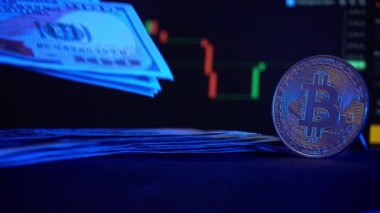 Kripto para biriminin arka planında büyüyen dolar yığını. Kağıt para, nakit para ve bitcoin. 100 dolarlık banknotlar. Kripto dünyasında yatırım başarısı.