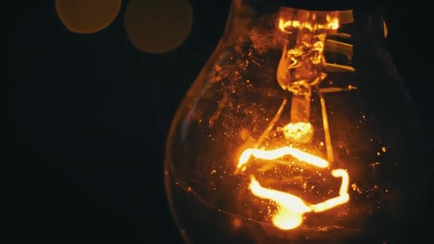 ヴィンテージの電球は点滅するライトの背景に対して光ります ペンダントの白熱ランプは黄金色の光で輝きます アイデアの生成 イノベーションと創造性 中光沢のある脳を持つランプ — ストック動画