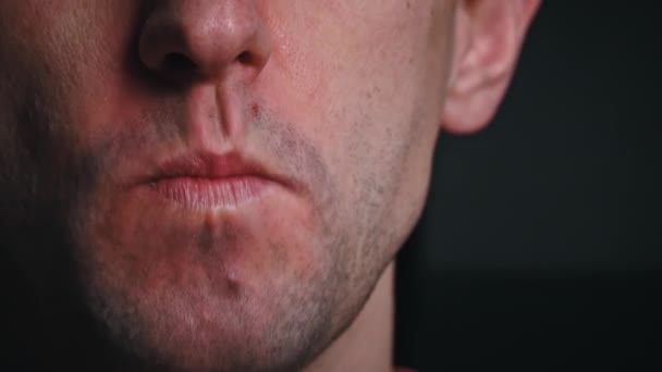 Mann Kaut Lebensmittel Zeitlupe Großaufnahme Auf Schwarzem Hintergrund Das Gesicht — Stockvideo