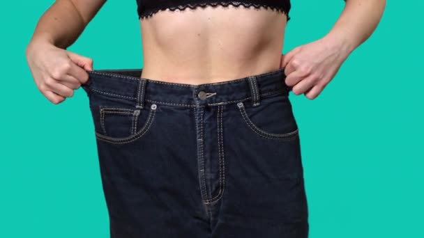 女性は大きなサイズのジーンズで体重を減らした後ウエストします 成功した体重減少 適切な栄養 そして健康の概念 スリムな美しい女性の不在 大きなズボンの薄い女性 — ストック動画