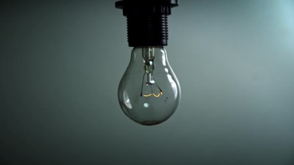 Light Bulb Flashes Blue Background Dark Slow Turning Tungsten Light — Video Stock