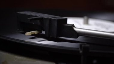 Eski bir retro çalgıcı yakın plan vinil plak çevirir. Vinil bir pikabın iğnesi diskteki yivlerin kayıtlarını okur. Antika bir pikapta klasik müzik çalıyor..