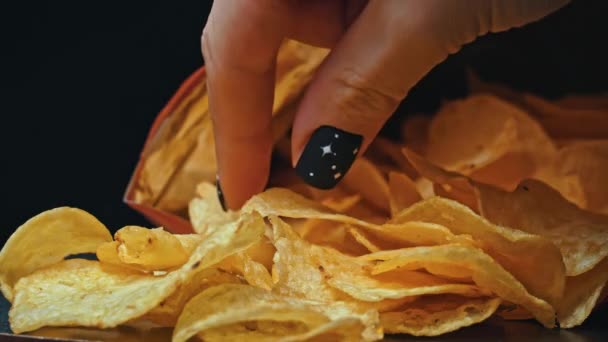 남자는 손으로 바삭바삭한 감자칩을 가져간다 건강에 해로운 패스트 푸드에 혼란스럽게 — 비디오